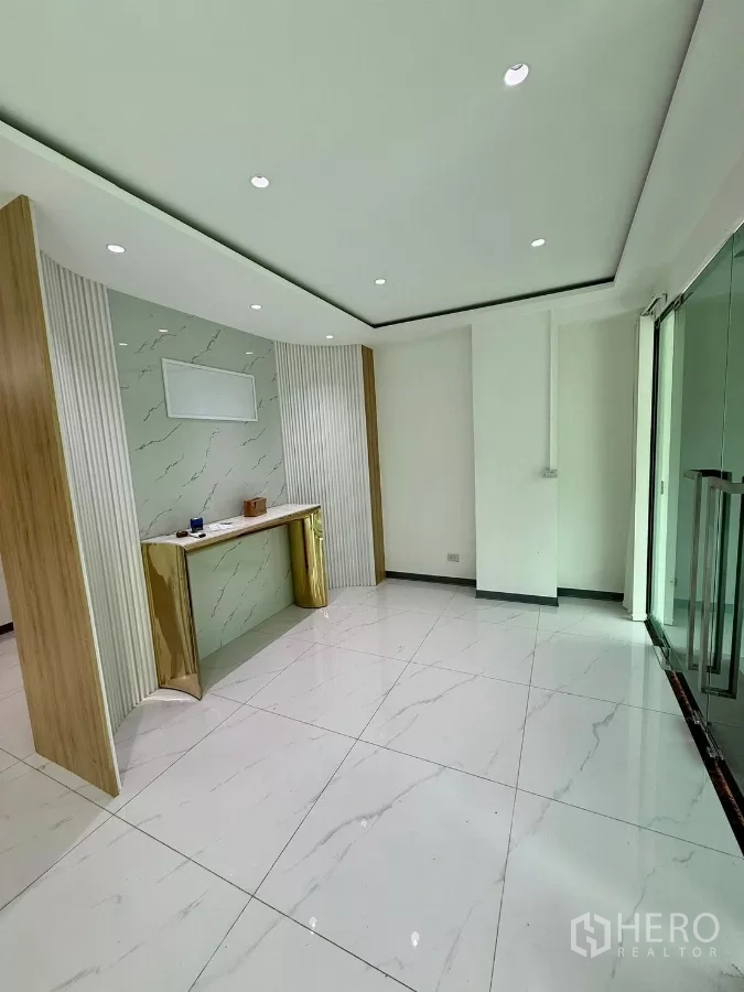 带办公室的家 出租或出售在Wang Thonglang, Bangkok - 接待区，仿大理石特色墙、玄关桌与玻璃门。