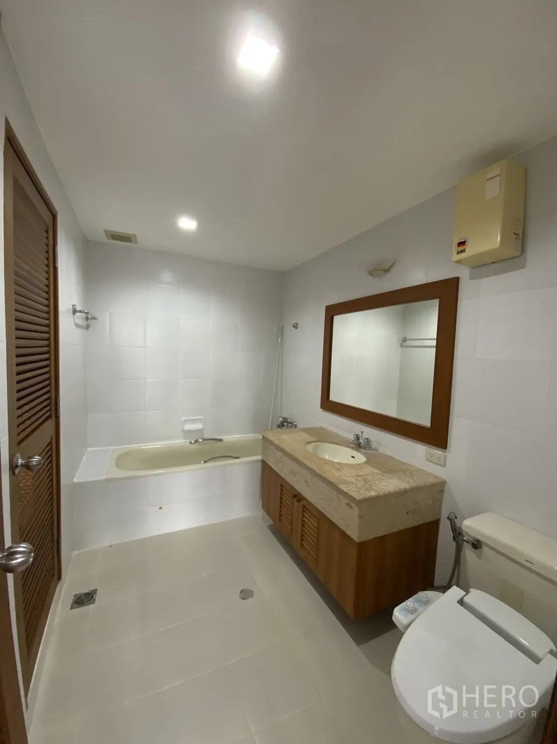 公寓 出租在Watthana, Bangkok - 浅色调卫浴，带浴缸、石面洗手台与坐便器。