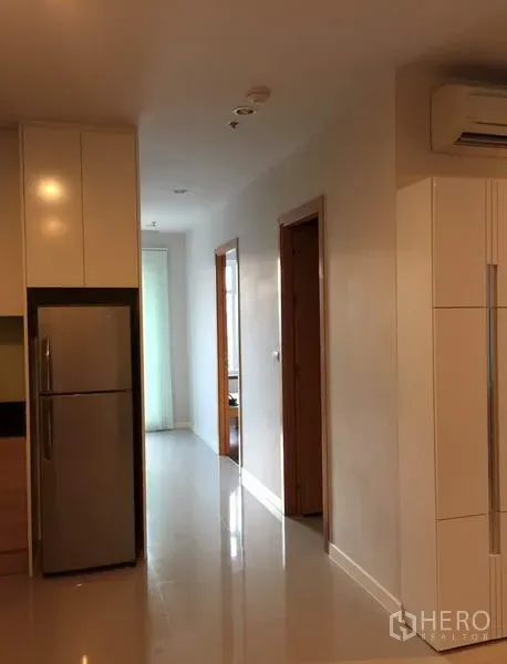 公寓 出租或出售在Ratchathewi, Bangkok - 通往卧室的走廊，亮面地砖，嵌入式柜体与不锈钢冰箱。