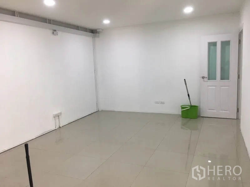 Home Office for rent or sale in Khlong Toei, Bangkok - Clean small office room with tiled floors, ceiling lights, and a white door.