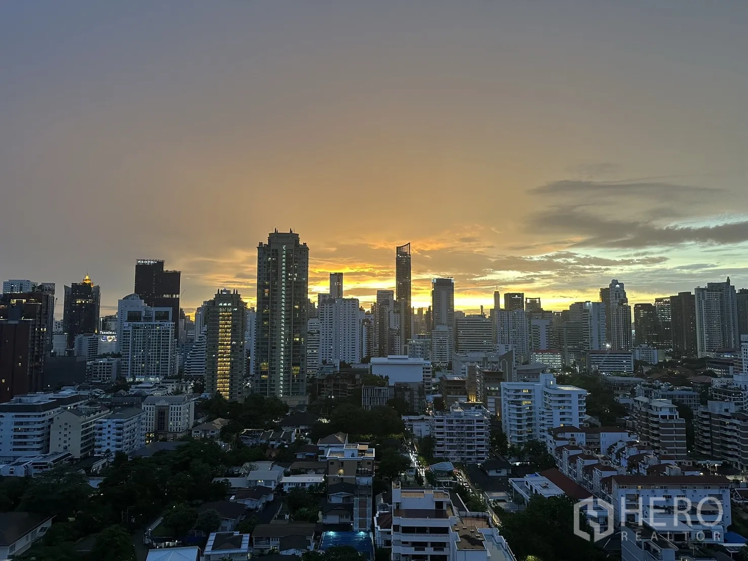Condominium for rent or sale in Watthana, Bangkok - High-floor skyline view of Bangkok at sunset.