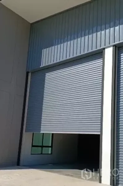 工厂 出售在Bang Bo, Samut Prakan - 工厂装卸区的高卷帘门与金属板立面特写。