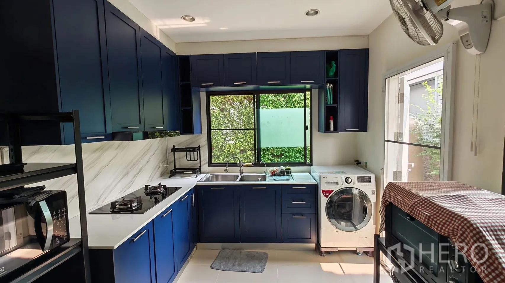 独栋房屋 for rent or sale in Bang Phli, Samut Prakan - U形厨房，蓝色柜体，燃气灶、双水槽、窗户与洗烘一体机。
