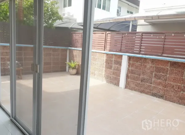 Detached House for rent in Lat Krabang, Bangkok - Private tiled patio viewed through sliding glass doors with high privacy fence.