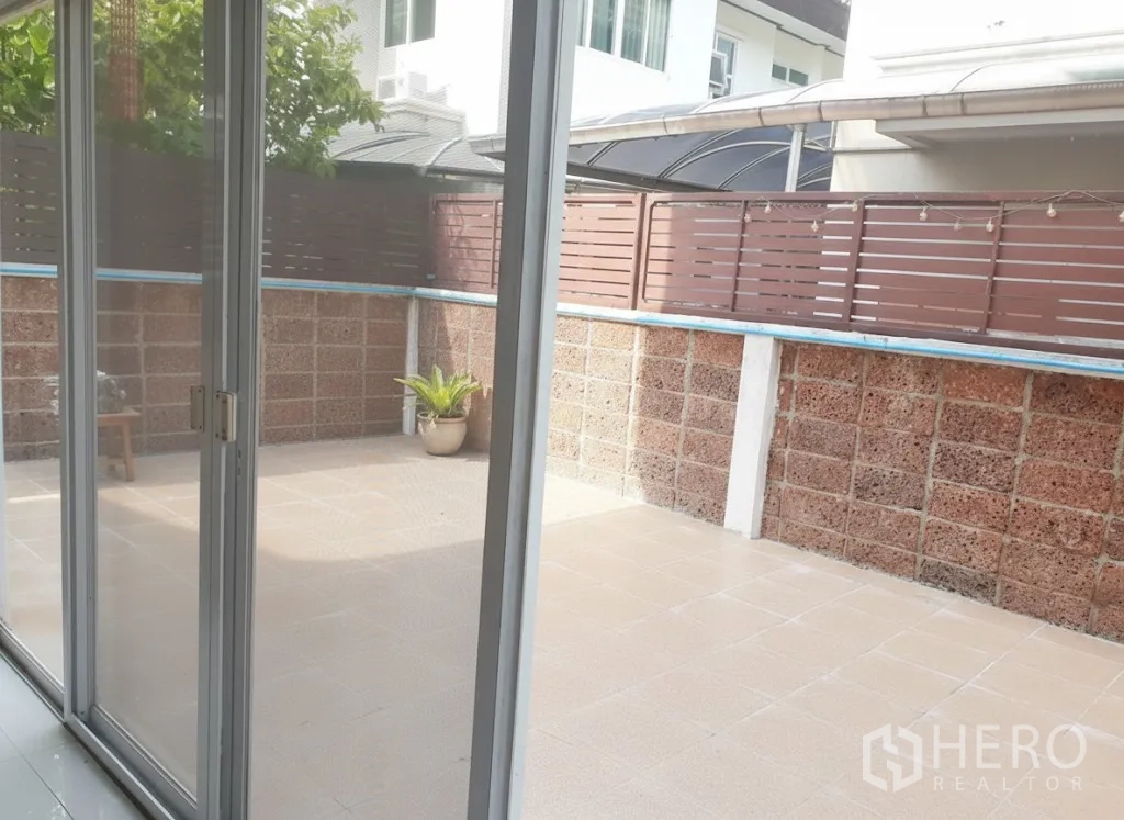 Detached House for rent in Lat Krabang, Bangkok - Private tiled patio viewed through sliding glass doors with high privacy fence.