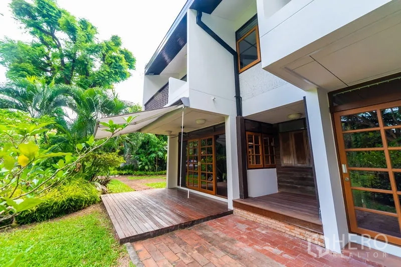 Detached House for rent in Huai Khwang, Bangkok - Covered wooden deck and brick patio adjoining the house with garden views.