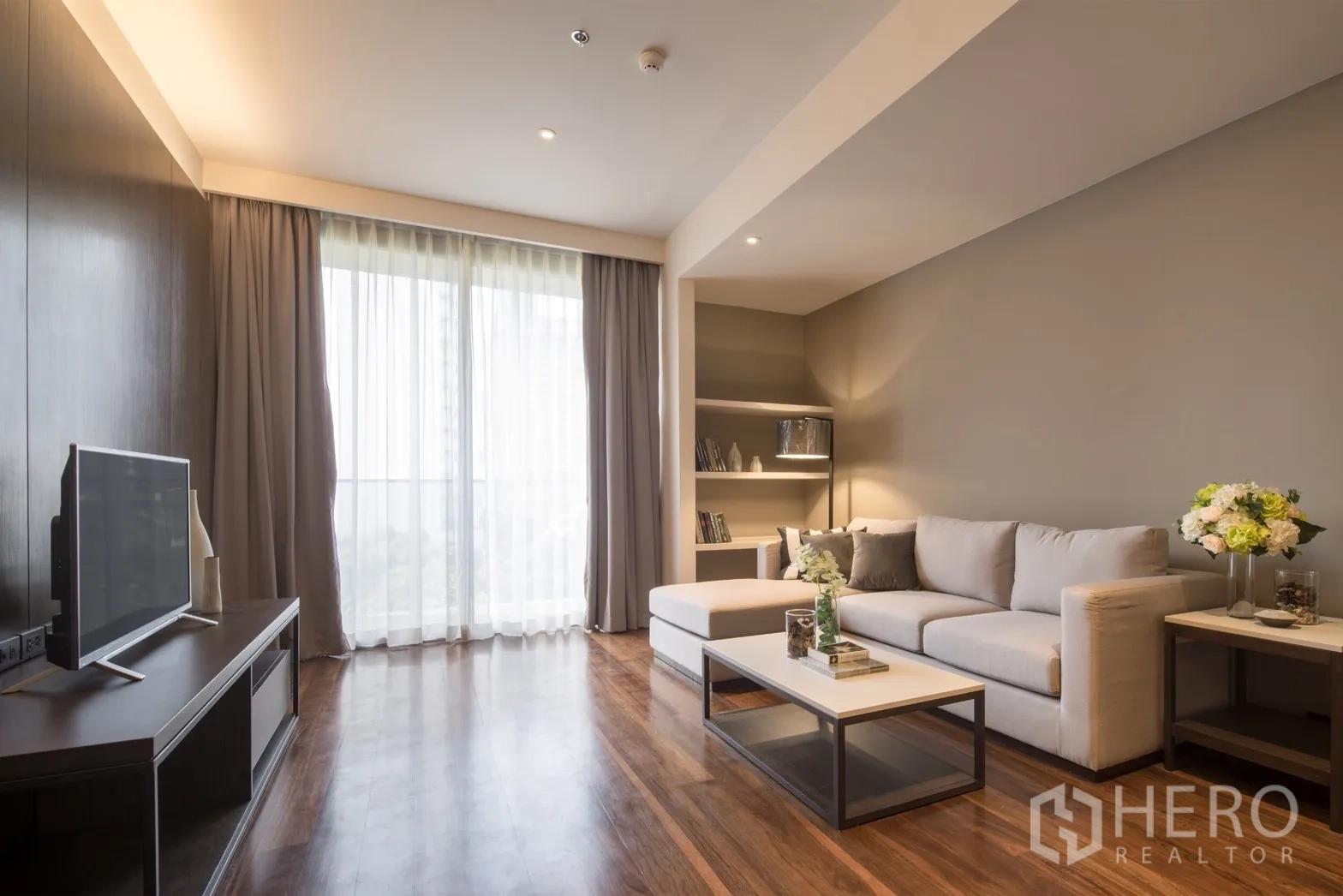 公寓 for rent in Khlong Toei, Bangkok - 明亮客厅，L形沙发、茶几与落地窗，靠近BTS澎蓬站的两卧公寓。