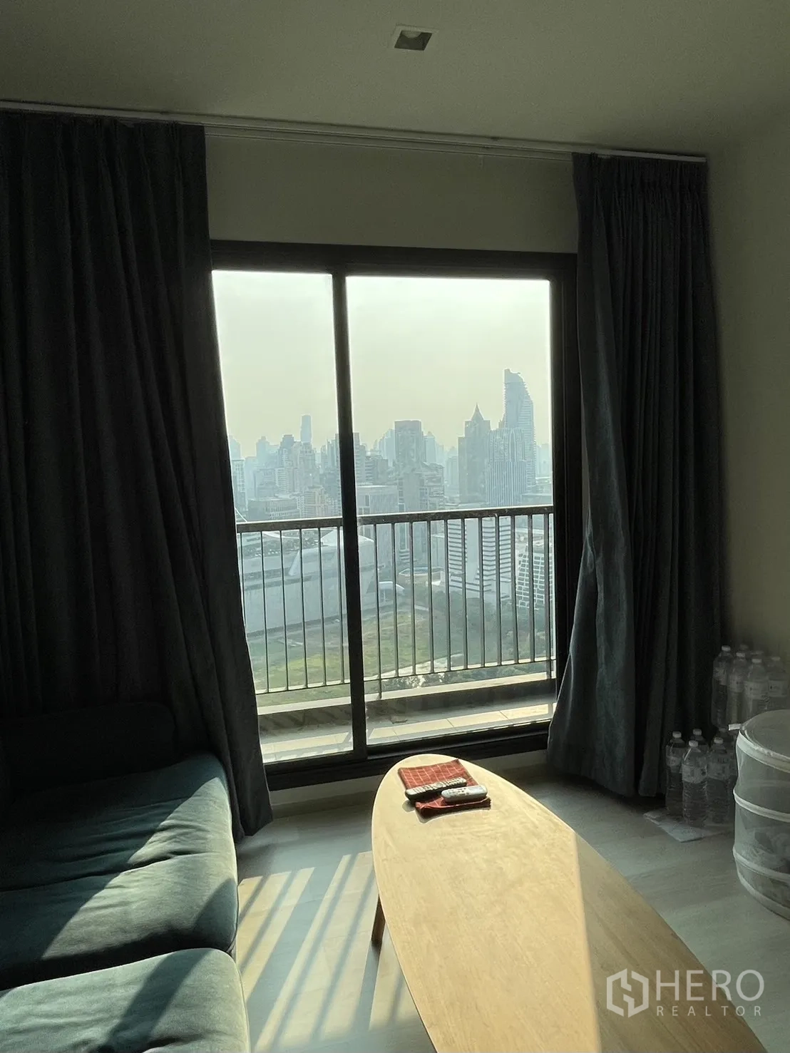 公寓 for rent in Pathum Wan, Bangkok - 客厅推拉玻璃门通阳台，茶几与远处城市景观。