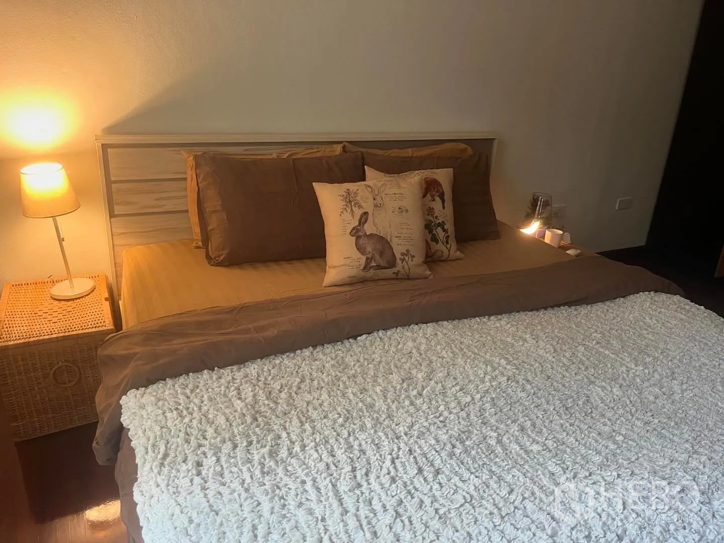 店屋 for rent in Bang Rak, Bangkok - 卧室特写，有暖色台灯与藤编床头柜。
