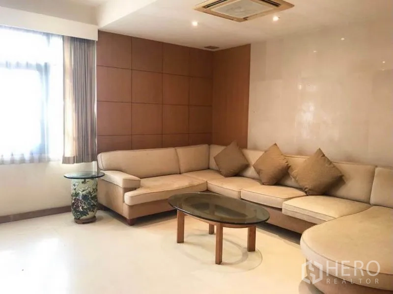 บ้าน ขายในMueang Samut Prakan, Samut Prakan - ห้องพักผ่อนพร้อมโซฟาเข้ามุม ผนังไม้ และโต๊ะกระจก