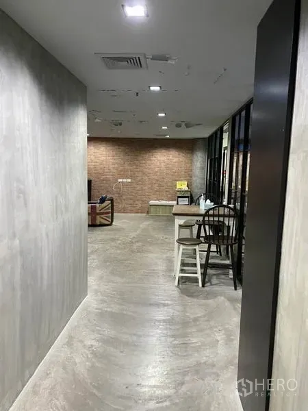 办公空间 出租在Khlong Toei, Bangkok - 工业风走廊，水泥墙面、嵌入式顶灯与砖墙休闲区。