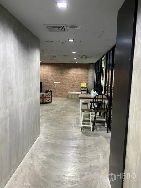 办公空间 出租在Khlong Toei, Bangkok - 工业风走廊，水泥墙面、嵌入式顶灯与砖墙休闲区。