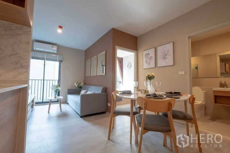 公寓 出租在Bang Na, Bangkok - 明亮的客餐厅一体空间，配沙发、圆桌与阳台，位于Bang Na公寓。
