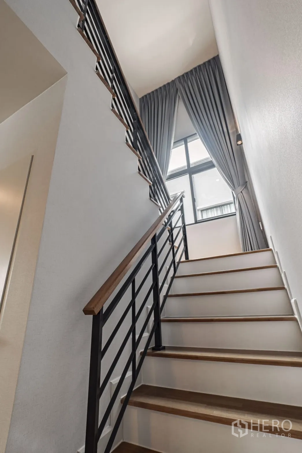 独栋房屋 for rent in Bang Phli, Samut Prakan - 木踏步楼梯，挑高窗配长窗帘采光充足。