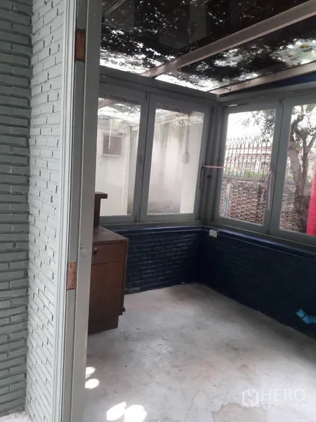 Detached House for rent in Watthana, Bangkok - Corner sunroom with floor-to-ceiling windows and exposed brick.