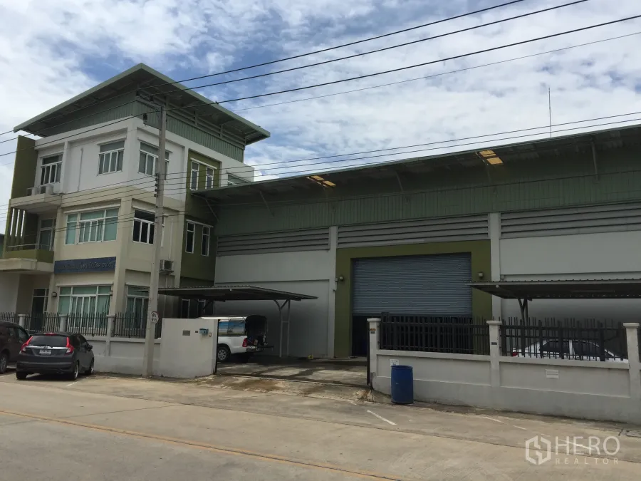 โรงงาน ขายในPathum Thani - โรงงานสมัยใหม่พร้อมอาคารสำนักงาน 3 ชั้น ประตูม้วนขนาดใหญ่ ลานขนถ่ายสินค้าแบบมีหลังคา และที่จอดรถภายในรั้ว บนถนนคอนกรีตในย่านลำลูกกา ปทุมธานี