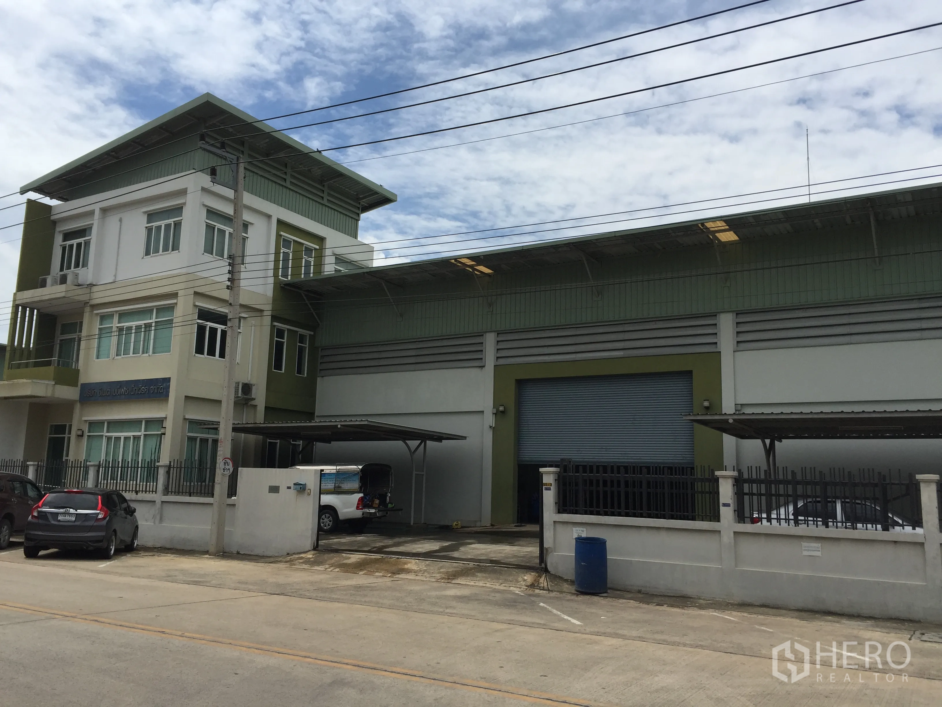โรงงาน ขายในPathum Thani - โรงงานสมัยใหม่พร้อมอาคารสำนักงาน 3 ชั้น ประตูม้วนขนาดใหญ่ ลานขนถ่ายสินค้าแบบมีหลังคา และที่จอดรถภายในรั้ว บนถนนคอนกรีตในย่านลำลูกกา ปทุมธานี