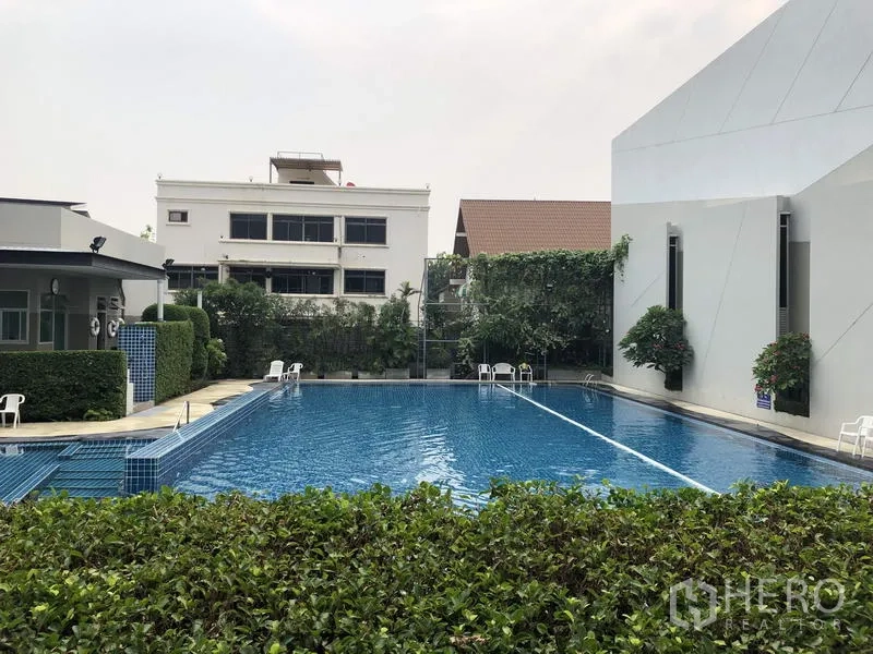 Detached House for rent in Khan Na Yao, Bangkok - Community facility with a large outdoor swimming pool and poolside seating.
