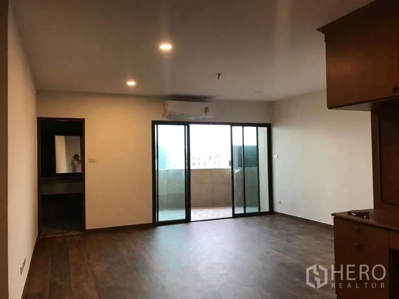 公寓 出售在Watthana, Bangkok - 大客厅，深色木地板，推拉门连通阳台。