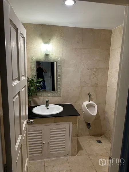 Townhouse for rent in Bang Kapi, Bangkok - Covered utility area with high metal roof and concrete floor.