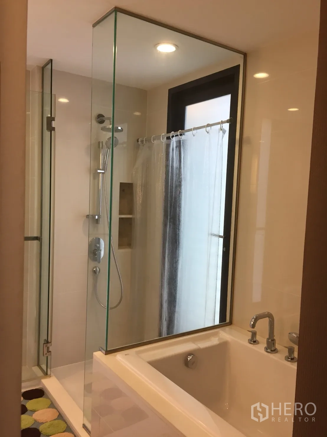 公寓 出租在Watthana, Bangkok - 浴室配玻璃淋浴间，旁边为浸泡浴缸与窗户。