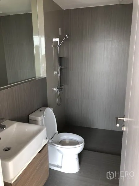 联排别墅 出售在Saphan Sung, Bangkok - 现代浴室，墙式花洒、坐便器与洗手台，灰色瓷砖。