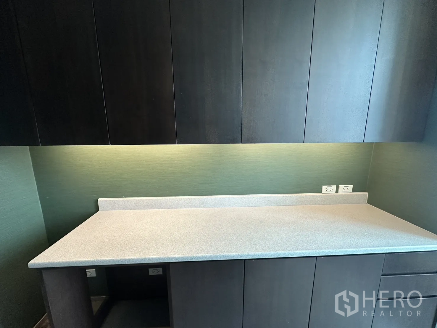 Office Space for rent in Watthana, Bangkok - Close-up of solid countertop with backsplash, outlets, and overhead cabinetry.