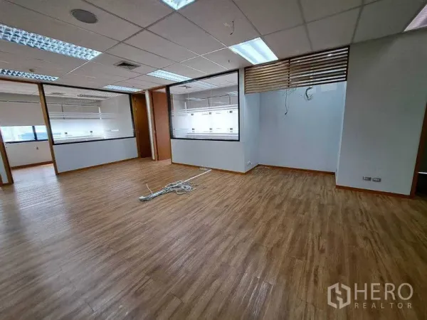 Office Space for rent in Bang Rak, Bangkok - Spacious office area with internal windows, partition walls and wood‑look floors.