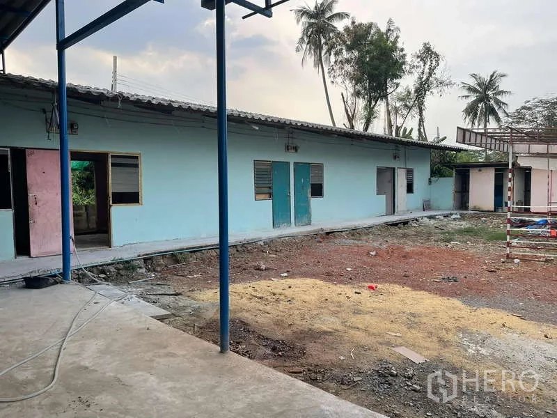 Warehouse for rent in Nong Khaem, Bangkok - Separate single-storey worker housing block with multiple rooms and doors.