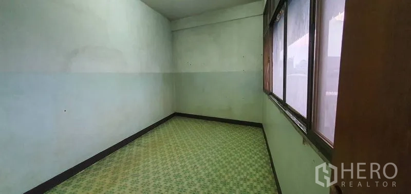 Warehouse for rent in Bang Kho Laem, Bangkok - Narrow room with patterned tile floor, long window, and mint walls.