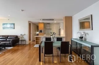 公寓 出租在Bang Rak, Bangkok - 餐区邻现代厨房，玻璃柜门与内置储物。
