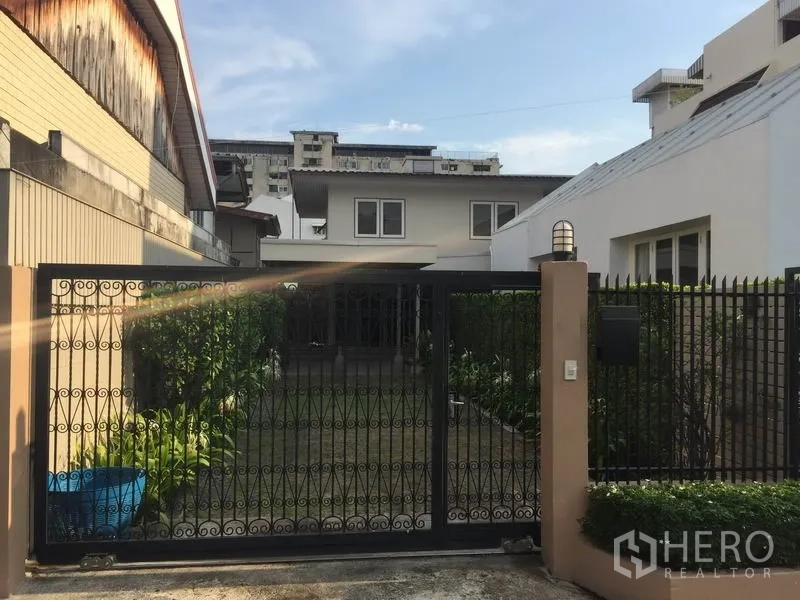 บ้าน ให้เช่าในKhlong Toei, Bangkok - มุมมองหน้าบ้านเดี่ยว พร้อมรั้วเหล็กดัดและสนามหญ้าจัดแต่ง