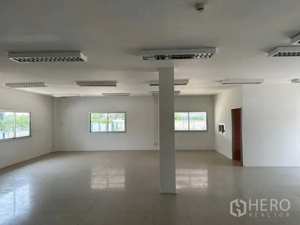 Warehouse for rent in Samut Prakan - Bright office room with tiled floors, white walls and multiple windows.