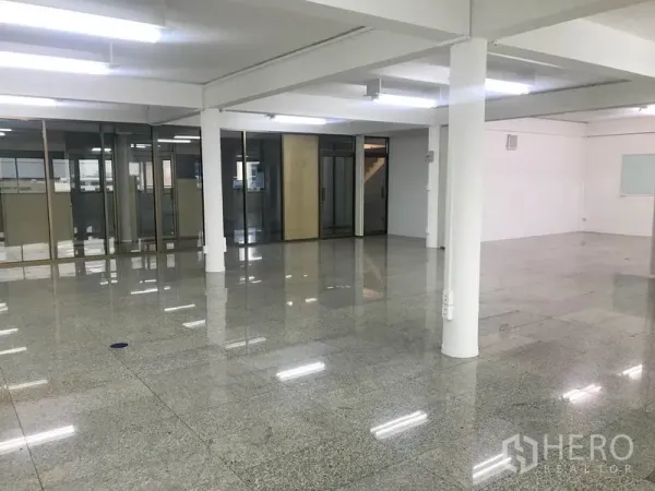 Office Space for rent in Suan Luang, Bangkok - Spacious empty office area with columns, ceiling lights, and full-height glass partitions.