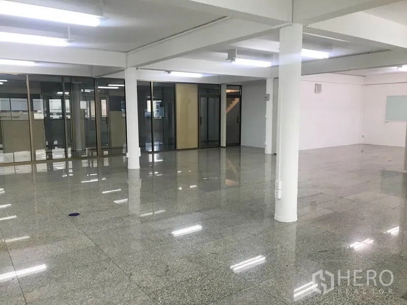 Office Space for rent in Suan Luang, Bangkok - Spacious empty office area with columns, ceiling lights, and full-height glass partitions.