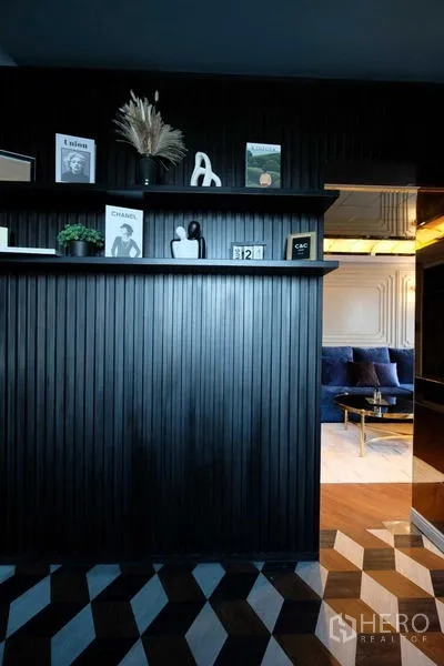 Condominium for sale - Entry corridor with black slatted wall and geometric flooring leading to the living room.