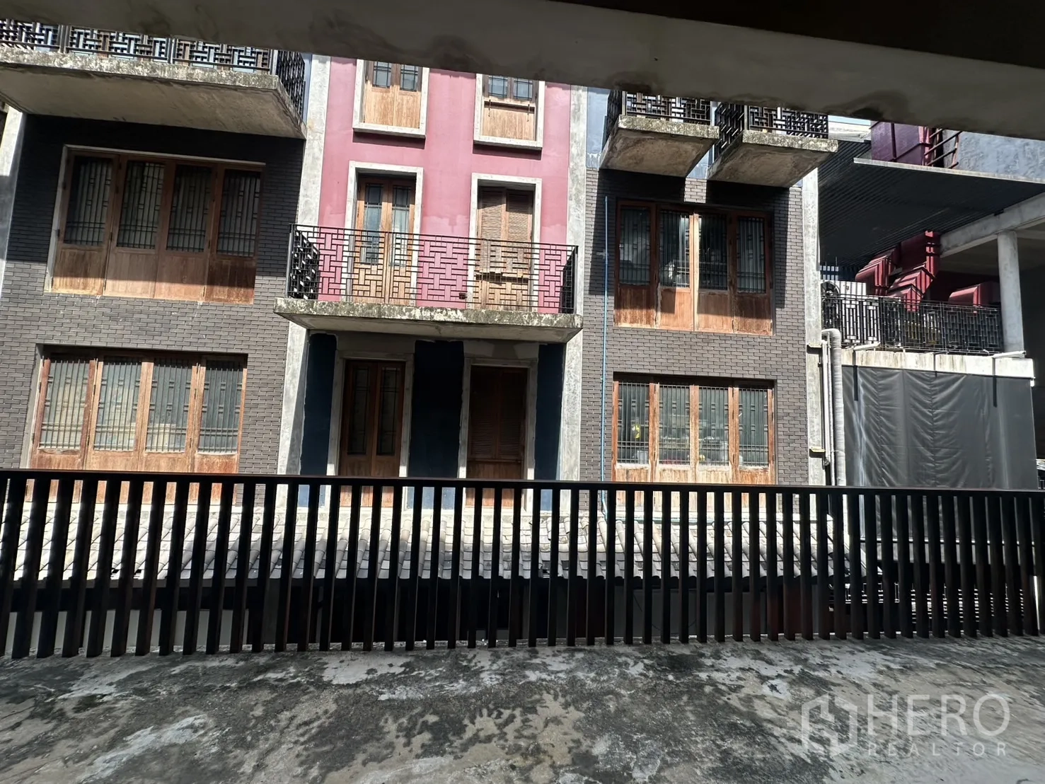 带办公室的家 出租在Pathum Wan, Bangkok - 阳台视角，望向对面的低层商住楼与金属栏杆。