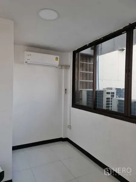 店屋 出售在Watthana, Bangkok - 带窗与分体空调的小型办公室，可见外部机房区域。