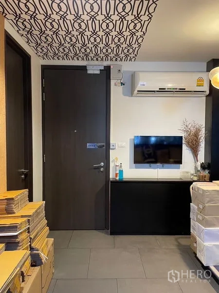 办公空间 出租在Phaya Thai, Bangkok - 入口墙面，挂装空调、壁挂电视与收纳柜。