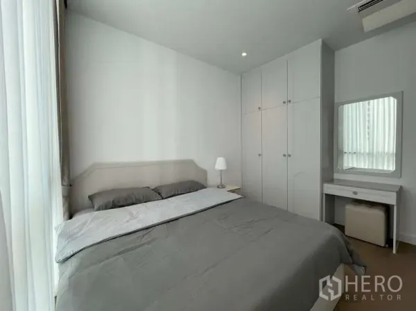 Condominium for rent or sale in Sathon, Bangkok - Cozy bedroom with built-in white wardrobe, vanity and soft lighting.