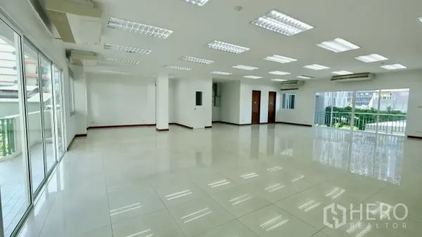 办公空间 出租 - 宽敞角落办公空间，照明充足，多扇门，推拉落地窗连接阳台。
