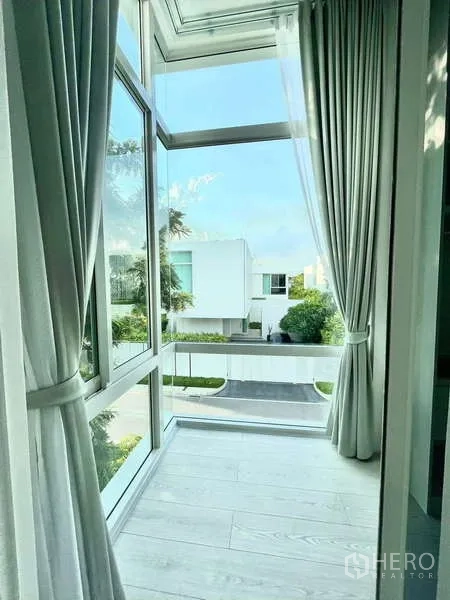 Detached House for rent or sale in Bang Phli, Samut Prakan - Corner glazing with full-height curtains overlooking a quiet residential street.