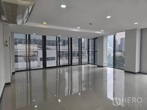 办公空间 出租在Sathon, Bangkok - 曼谷沙吞明亮转角办公室，落地窗、亮面瓷砖地板与城市景观。