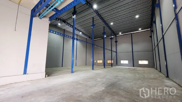 Warehouse for rent in Krathum Baen, Samut Sakhon - Open storage bay with steel structure, bright LED lighting, and smooth concrete flooring for heavy-duty operations.