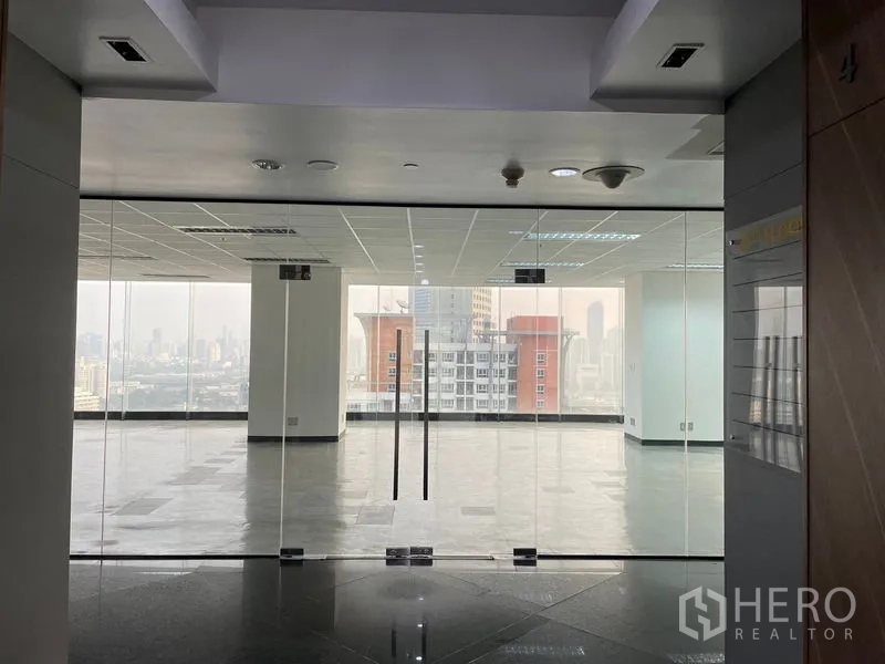 Office Space for rent in Din Daeng, Bangkok - Glass double-door entrance to the office suite with a skyline backdrop.