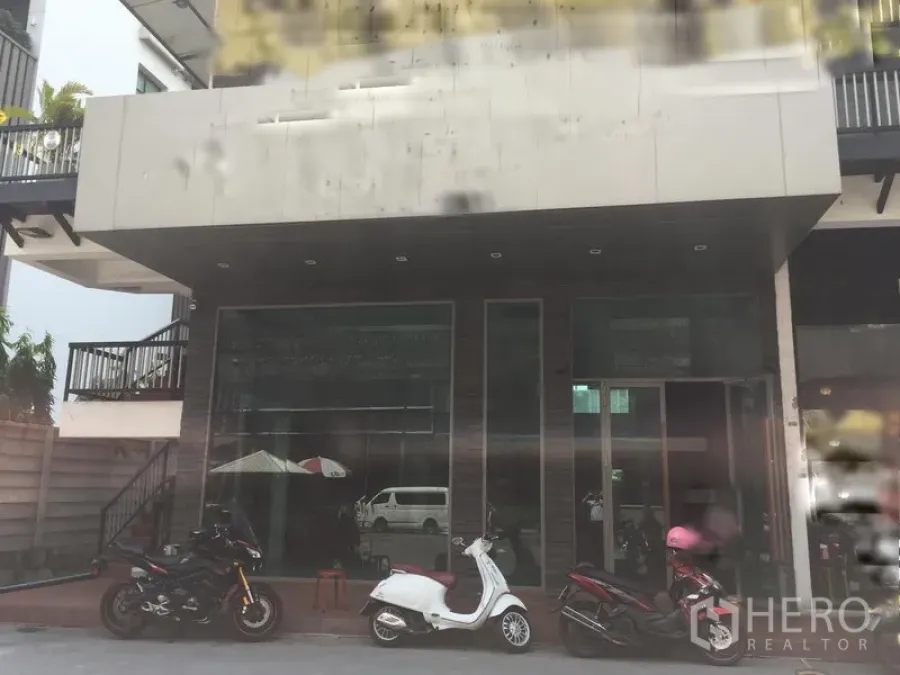 零售空间 出租在Khlong Toei, Bangkok - 一层临街店面，整面玻璃立面与雨棚，门前停有摩托车