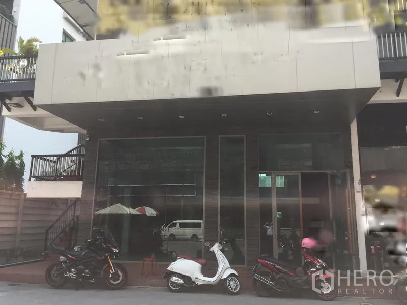 零售空间 出租在Khlong Toei, Bangkok - 一层临街店面，整面玻璃立面与雨棚，门前停有摩托车