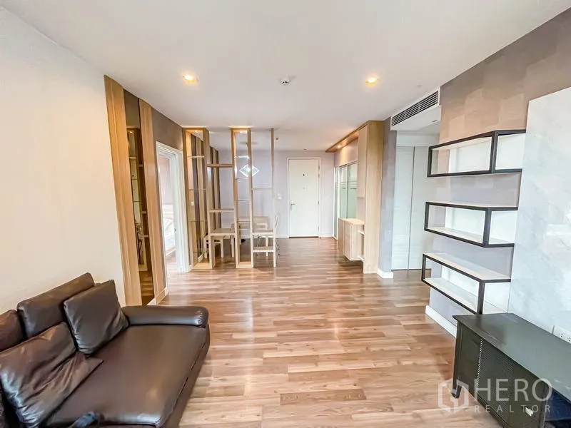 Condominium for sale - Open-plan living and dining space with spotlighted shelving and wood flooring.