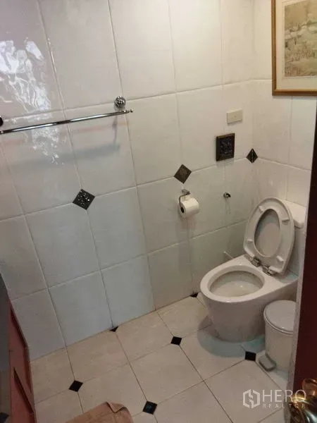 公寓 出租在Pathum Wan, Bangkok - 白色瓷砖浴室，马桶、毛巾架与菱形装饰砖。