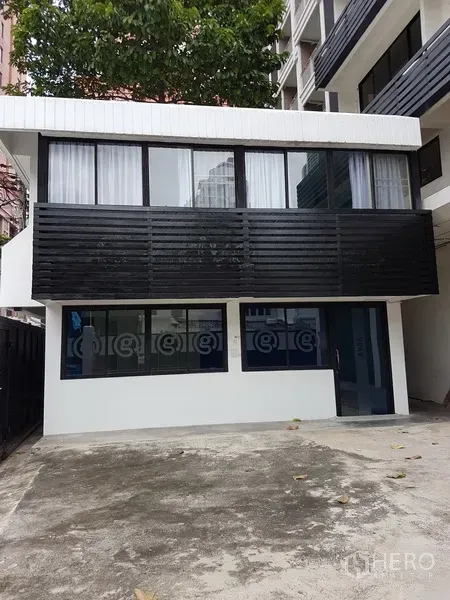 Home Office for sale in Khlong Toei, Bangkok - Detached annex building with wide windows facing a concrete yard.